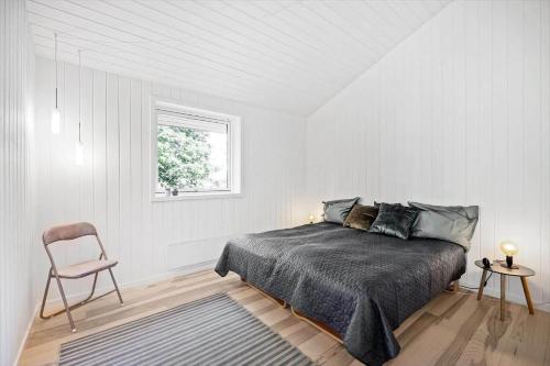 a bedroom with a bed and a chair and a window at 8535-Glesborg-Havstokken-12 in Glesborg