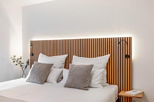 a bed with white pillows and a wooden headboard at O'Schwarzwald in Münstertal
