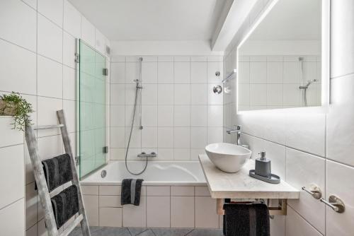 a bathroom with a sink and a bath tub at O'Schwarzwald in Münstertal