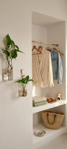 a room with a shelf with clothes and a plant at Apeiron Acropolis Suites by HC in Athens