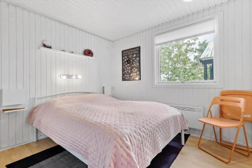 a bedroom with a pink bed and a window at 84159-Ebeltoft-Koravej-5 in Ebeltoft