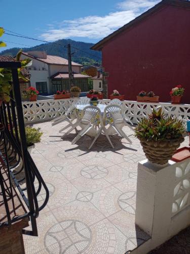 a patio with a table and chairs and a fence at CASA EL CASTAÑÉU in Arriondas