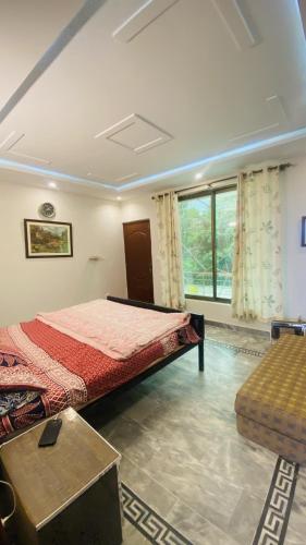 a bedroom with a bed and a large window at Luxury Apartment in Khaira Gali