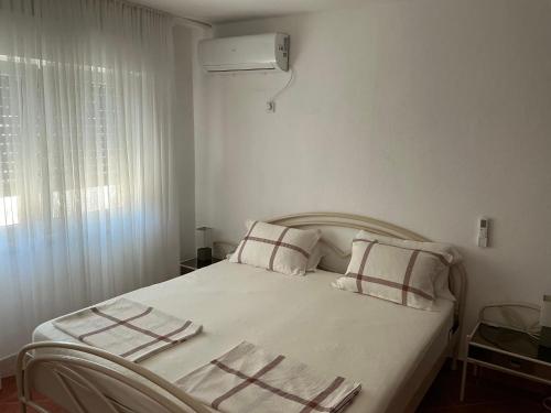 a bedroom with a white bed with two pillows at Apartment Dorada in Dobra Voda