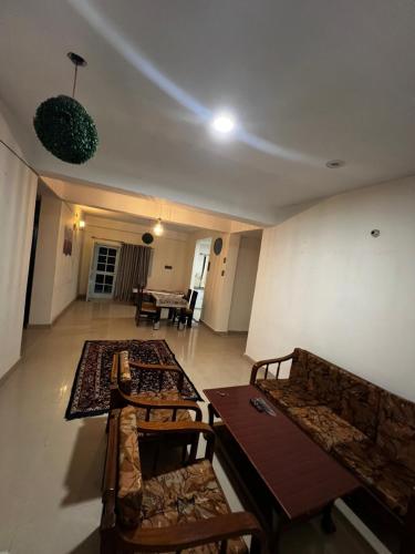 a living room with couches and a table and chairs at Pine & Peaks in Patta
