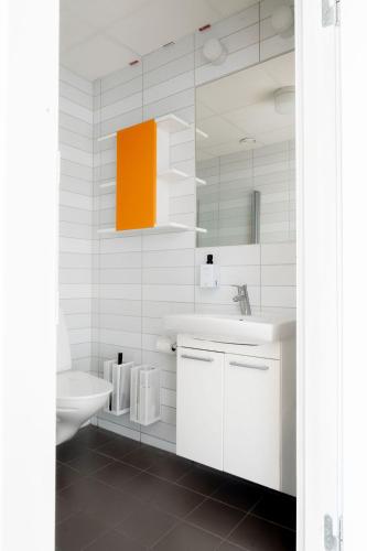 a bathroom with a sink and a toilet and a mirror at Sky Hotel Apartments Tornet in Linköping