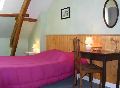 a bedroom with a purple bed and a desk at La Rivetière in Courcemont