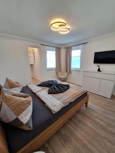 a bedroom with a large bed and a flat screen tv at Murtal Appartement Größingblick Top 1 in Zeltweg