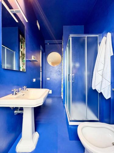 a blue bathroom with a sink and a shower at Nuvola 24 - Casa Vacanza in Rimini