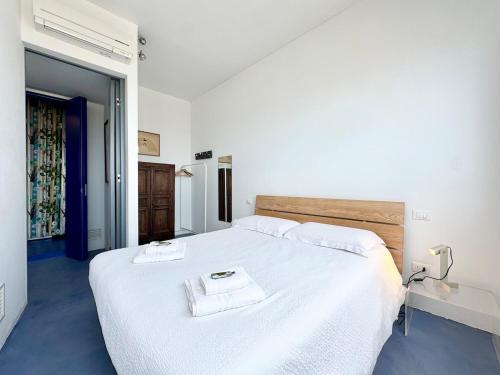 a bedroom with a large white bed with two towels on it at Nuvola 24 - Casa Vacanza in Rimini