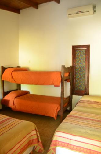 a room with three bunk beds in a room at Hotel Carmen de Areco in Carmen de Areco
