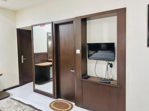 a room with two glass doors and a television at Hotel President, Pure Veg in Indore