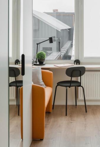 an office with an orange chair and a desk at Cosy apartment in Vilnius