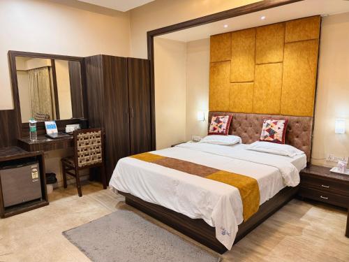 a bedroom with a large bed and a desk at Hotel President, Pure Veg in Indore