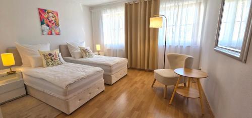 a hotel room with two beds and a table at Lake&Mountain Apartments in Andechs