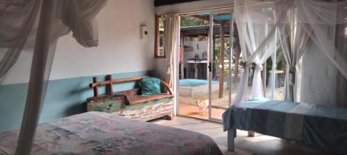 a bedroom with a bed and a view of a patio at Shongili Island Lodge in Vila Praia Do Bilene
