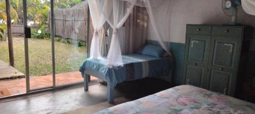 a bedroom with a bed and a window at Shongili Island Lodge in Vila Praia Do Bilene
