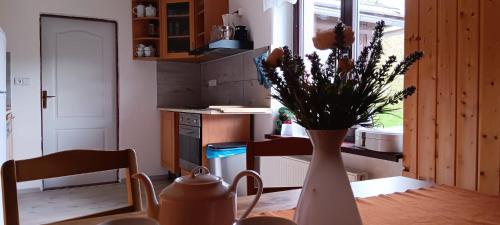 a vase with flowers on a table in a kitchen at Vila Pramínek, Krkonoše s bazénem kousek od Pece pod Sněžkou in Horní Maršov
