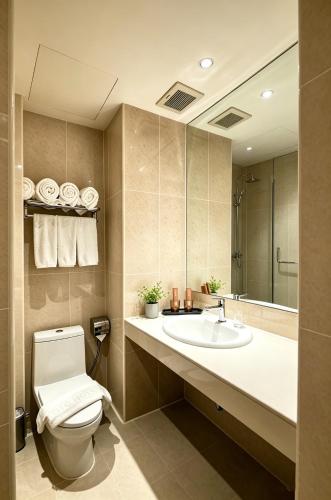 a bathroom with a toilet and a sink and a mirror at BTC Hotel 比特币酒店 in Malacca