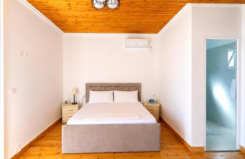 a bedroom with a bed and a wooden ceiling at PRIAM Beach Borsh in Borsh