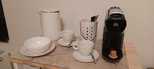 a table with cups and plates and a blender at Vila Pramínek, Krkonoše s bazénem kousek od Pece pod Sněžkou in Horní Maršov