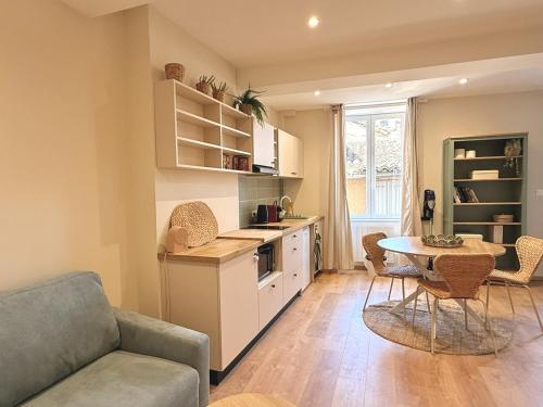 a kitchen and living room with a table and a couch at Le Stervin in Villefranche-sur-Saône