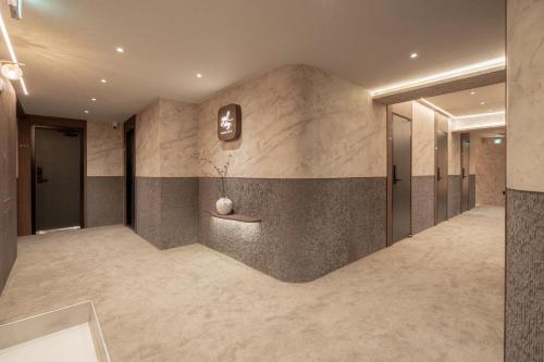 a hallway of a hotel lobby with a wall of marble at yulstay in Seoul