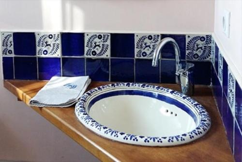 a bathroom sink with a blue and white tile at Domaine Mariedal in Hauterives
