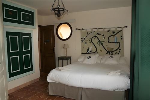 a bedroom with a white bed with a black headboard at Domaine Mariedal in Hauterives