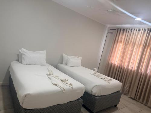 two beds sitting next to each other in a room at Dreams Apartments in Victoria Falls