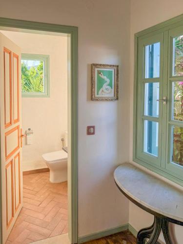 a bathroom with a table and a toilet and a window at LAGO Skiathos Guest Suites in Skiathos