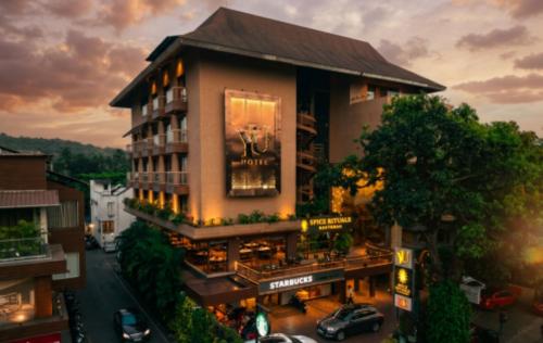 a building with a sign on the side of it at Yu Hotel, Candolim in Candolim