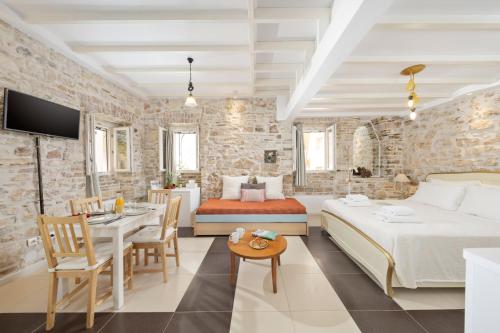 a hotel room with a bed and a dining room at Corfu Breeze Liston Apartments in Corfu