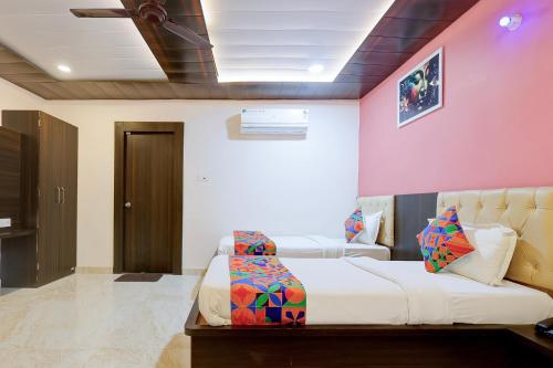 a bedroom with a white bed and a pink wall at Fabhotel Imperial 900 m from Sarnath Museum in Varanasi