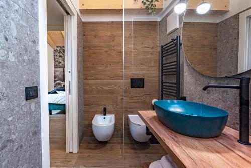 a bathroom with a blue tub and a sink at Alpine Lodge Green by Tss - Downtown, classy in Levico Terme