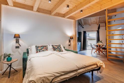 a bedroom with a bed and a wooden ceiling at Alpine Lodge Green by Tss - Downtown, classy in Levico Terme