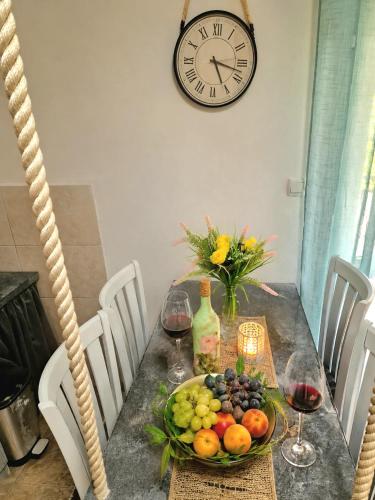 a table with a plate of fruit and a clock at Eco Bay Montenegro in Donji Morinj