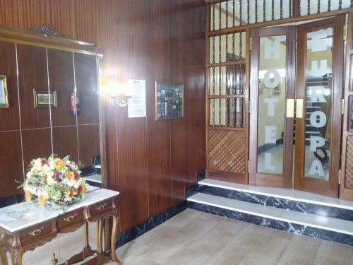 a lobby with stairs and a vase of flowers at Hotel Europa in Tomelloso