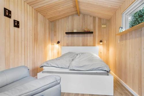 a small bedroom with a bed in a wooden wall at 30640-Odder-Magevej-7 in Odder