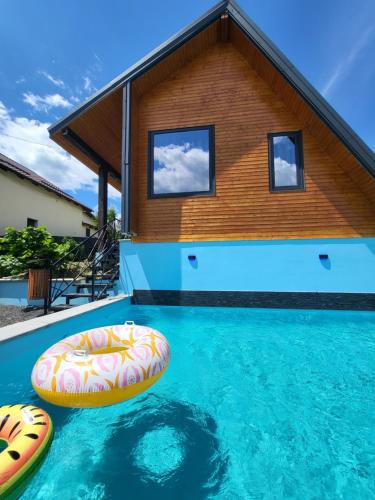a house with a swimming pool with two inflatables at All4you Chalet Călimănești in Jiblea Veche