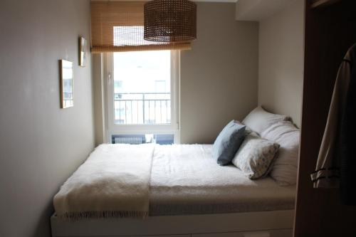 a bed in a room with a window at Moderne toppleilighet i Bergen in Bergen