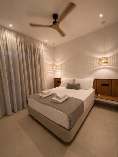 a bedroom with a large bed with two towels on it at Salsedo Seaside Rooms in Kanali