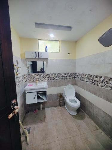 a bathroom with a toilet and a sink at Stylish Apartment in Khaira Gali