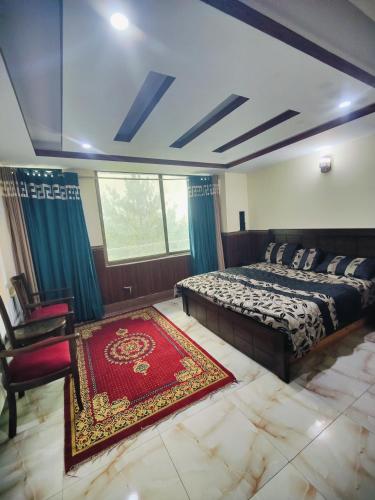 a bedroom with a bed and a red rug at Stylish Apartment in Khaira Gali