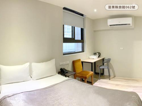 a bedroom with a bed and a desk in it at WE Hotel in Miaoli