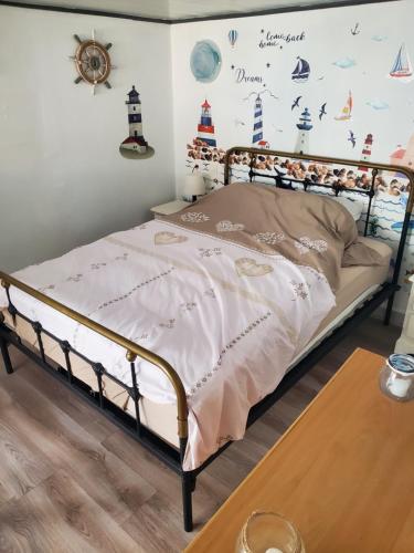 a bedroom with a bed and a wall with a lighthouse mural at Les flots d'Émilie et Vincent in Barneville-Carteret