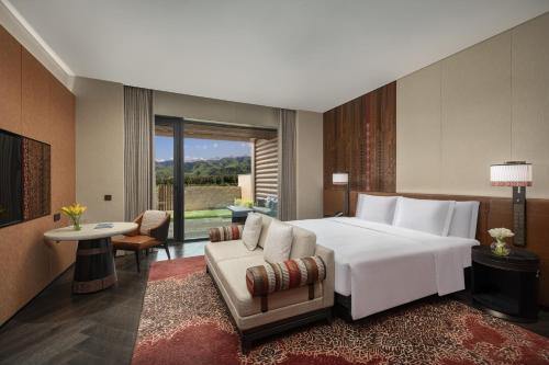 a bedroom with a large white bed and a chair at Hotel Indigo Nalati by IHG in Narat