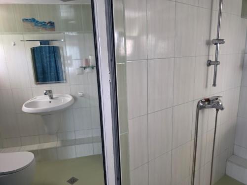 a bathroom with a shower and a toilet and a sink at Sinemoria apartment in Sinemorets