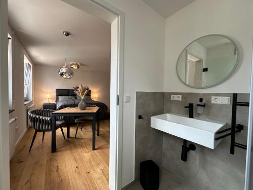 a bathroom with a sink and a table and a mirror at TIME OUT Apartments in Balingen
