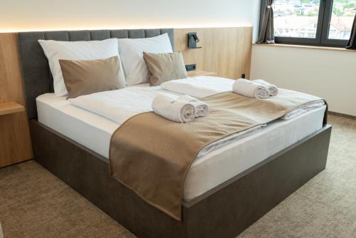 a large bed with two towels on top of it at Superior Rooms Bohorč in Šentjur